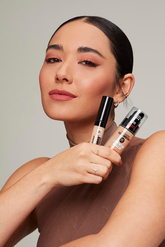woman holding two concealers